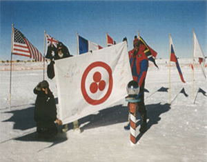De izquierda a erecha: V.Chukov (Rusia), V.Drabo (Bielorrusia) y el empleado de la estación  americana polar "Amundsen-Skott" con la Bandera de la Paz. El Polo Sur. 8 de enero de 2000